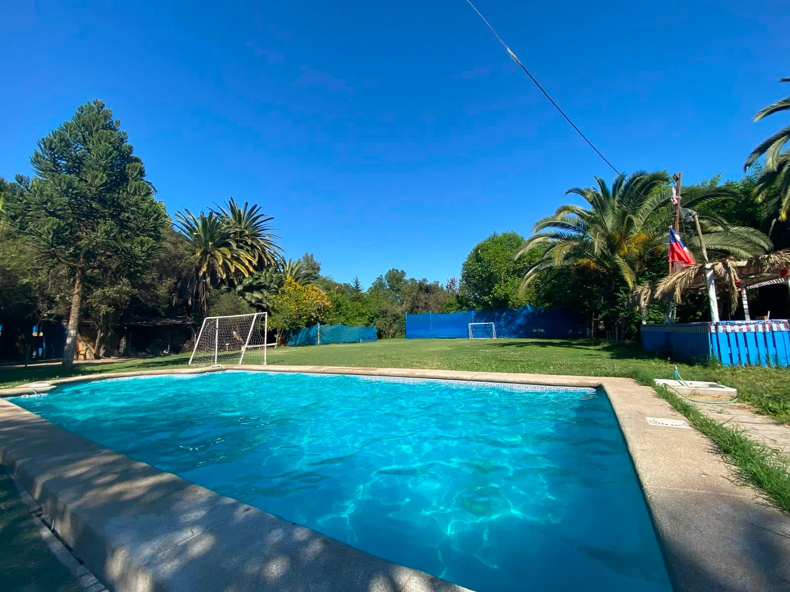 Piscina exterior del centro con la cancha de fútbol al fondo