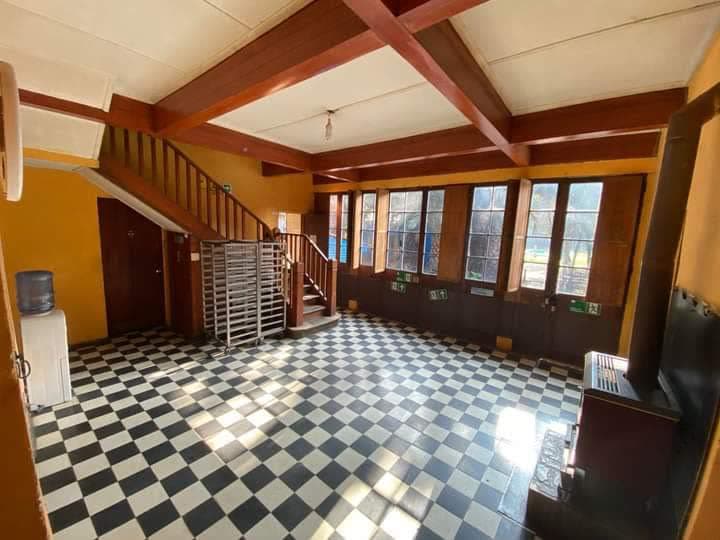 Sala interior con piso ajedrezado y escalera de madera